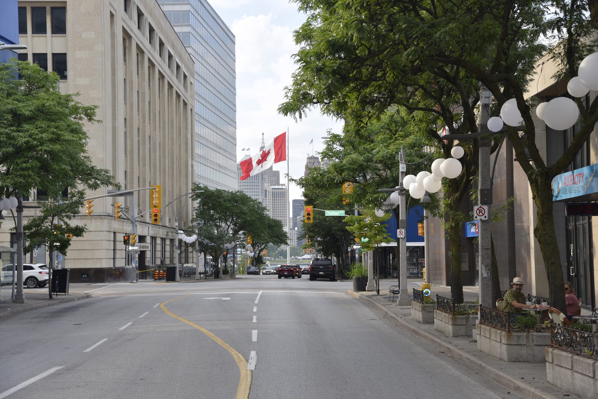 A tree-lined downtown Windsor street with outdoor cafe seating
